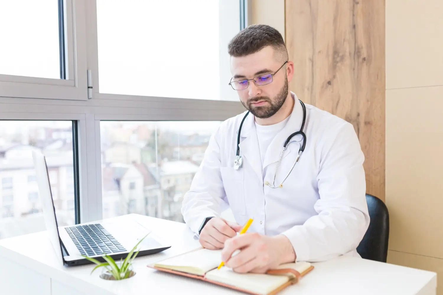 Conheça a reforma tributária para médicos: Foto de um médico em seu escritório fazendo cálculos tributários