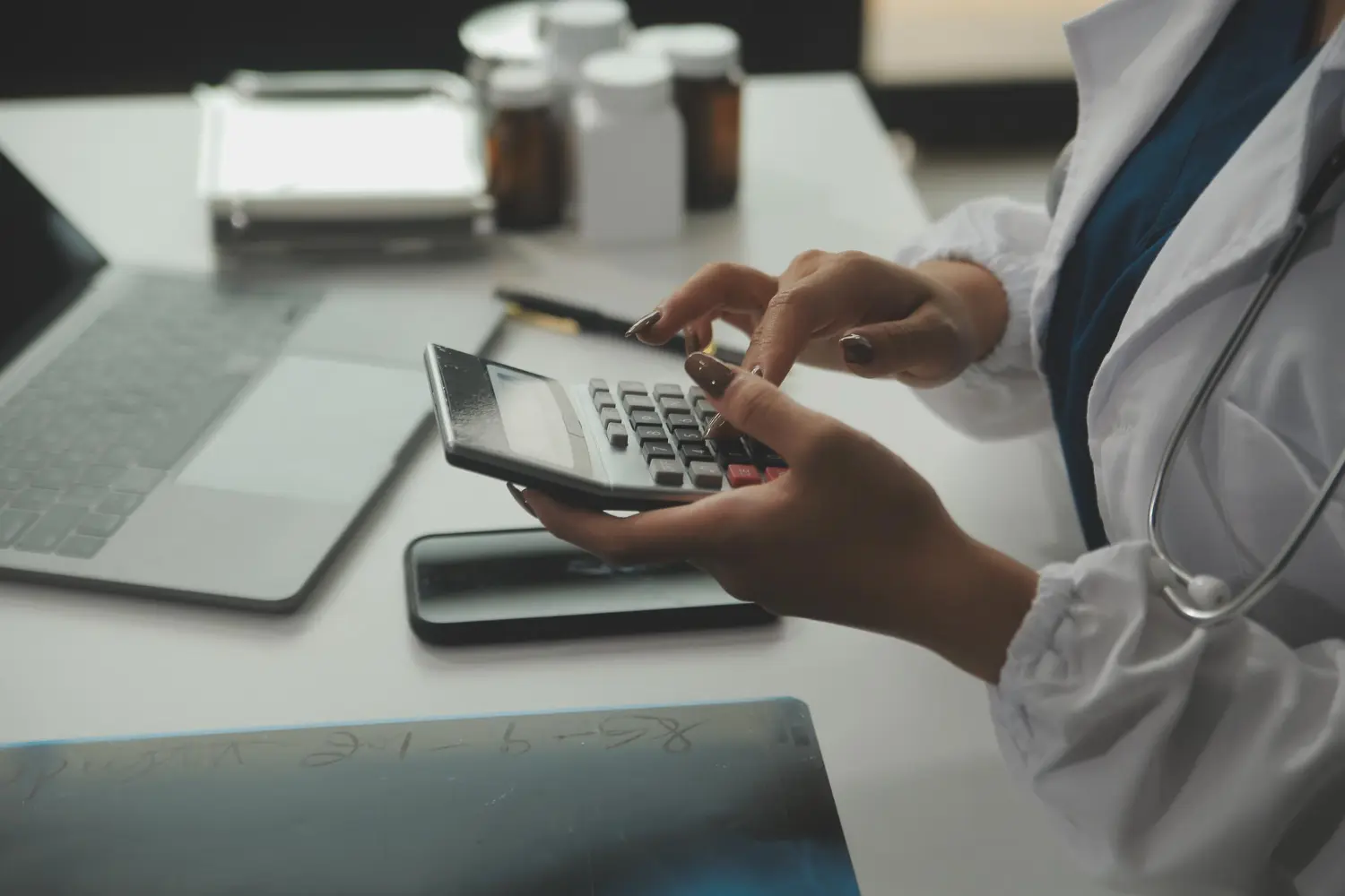 Regimes tributários para médicos: Foto de uma médica fazendo cálculos sobre seus gastos