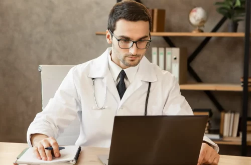 Principais deduções fiscais para médicos: Foto de um médico pesquisando sobre deduções fiscais para sua clínica