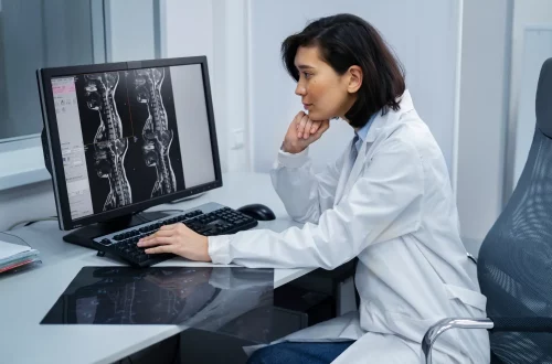 Equiparação hospitalar para radiologistas: Foto de uma radiologista analisando imagens de um paciente