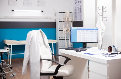 Erros mais comuns na gestão financeira de clínicas e consultórios: Foto de uma clínica médica com um computador mostrando dados dos pacientes