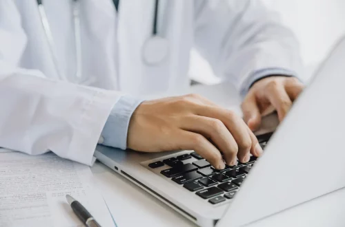 O que é DMED: Foto de um médico trabalhando em seu computador