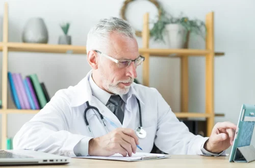 Planejamento tributário para médicos: Foto de um médico em seu consultório realizando planejamento tributário