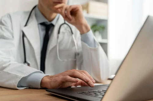 Planejamento tributário para médicos: Foto de um médico pesquisando em seu computador sobre planejamento tributário