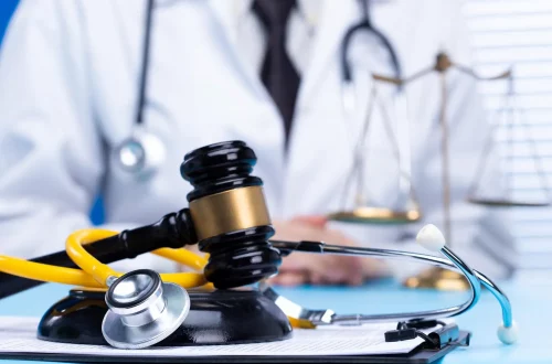 Os principais processos contra médicos: Foto de um médico atrás da balança da justiça simbolizando um processo legal.