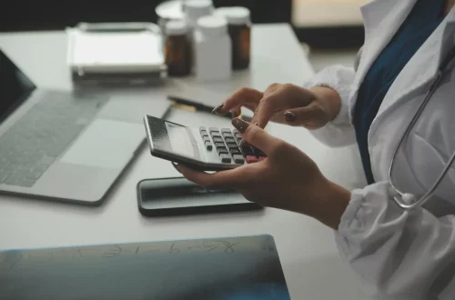 Regimes tributários para médicos: Foto de uma médica fazendo cálculos sobre seus gastos
