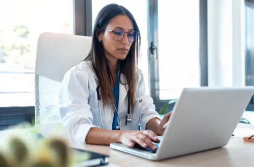 Whatsapp para médicos: Foto de uma médica utilizando o computador em seu escritório